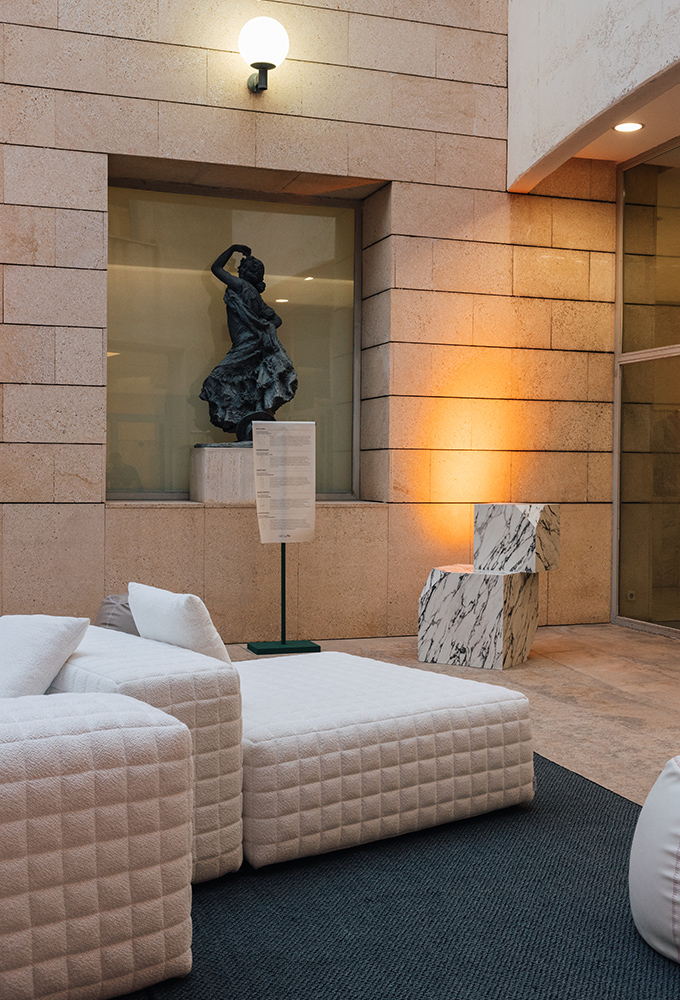 Mobiliario tapizado y alfombra junto a una escultura en el Museo de Bellas Artes de València