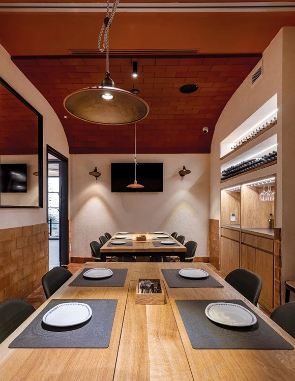 Mesas y bancos de una zona del comedor de Cassalla diseñada por Janfri & Ranchal