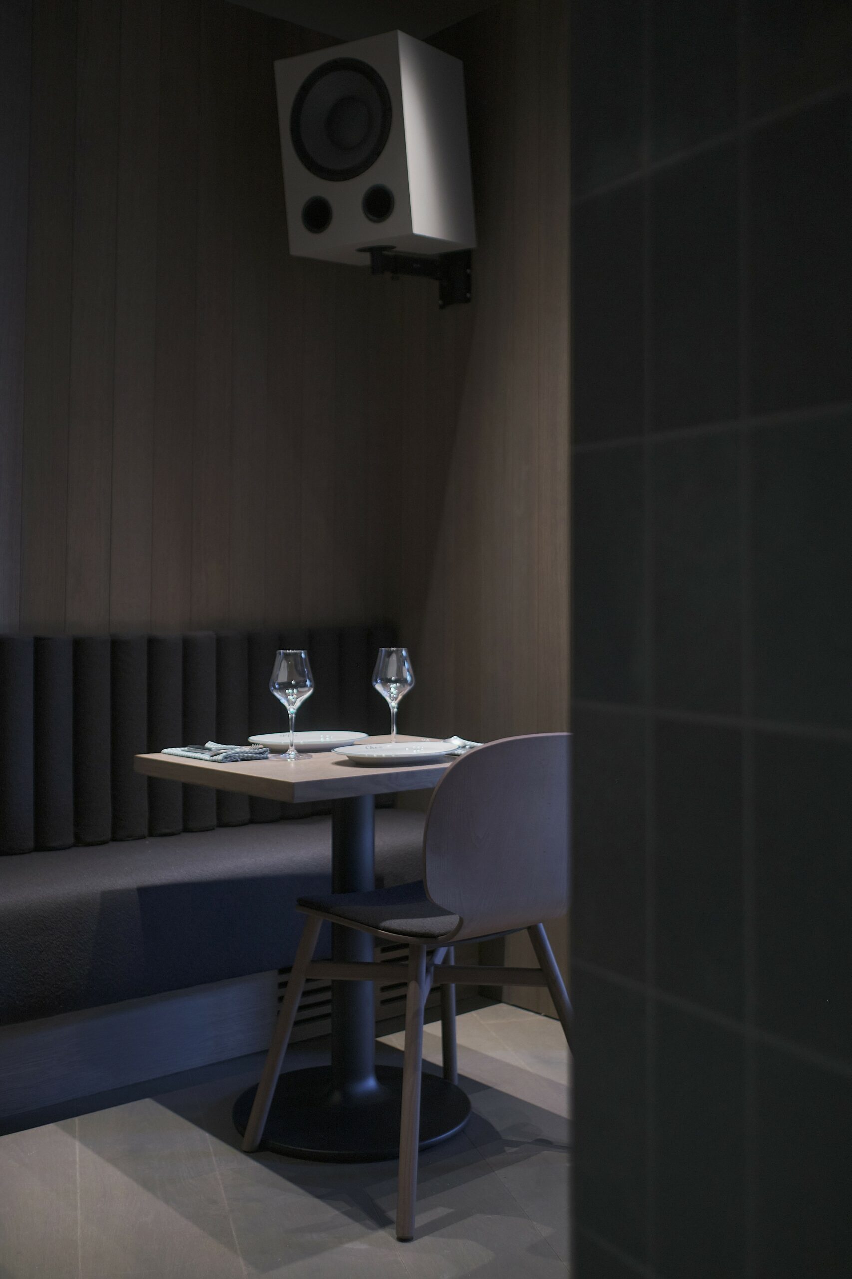 Rincón de comedor de Chez Filete con revestimientos de roble y cerámica verde