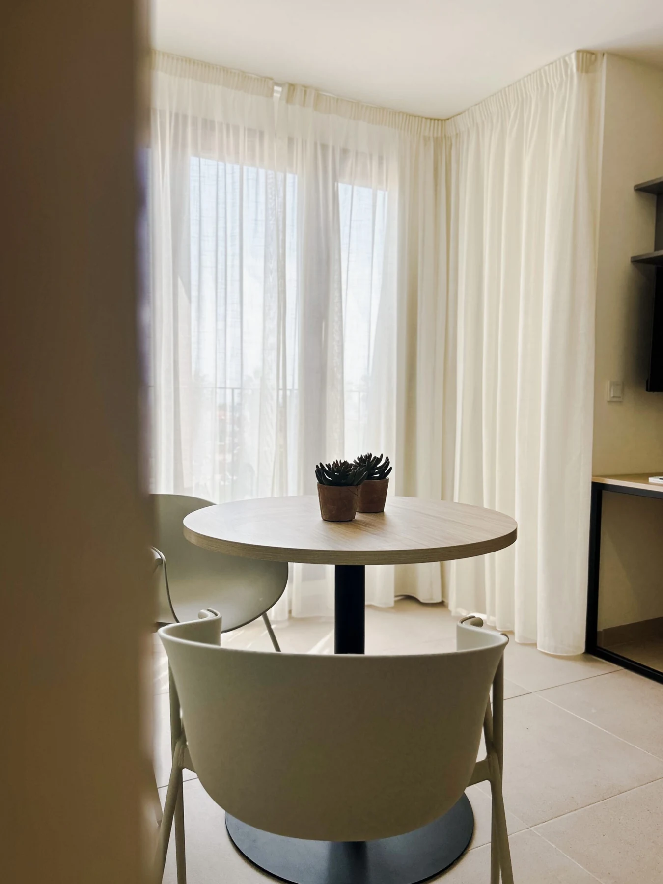 Mesa redonda y sillas en la zona de comedor del coliving Dr. Lluch