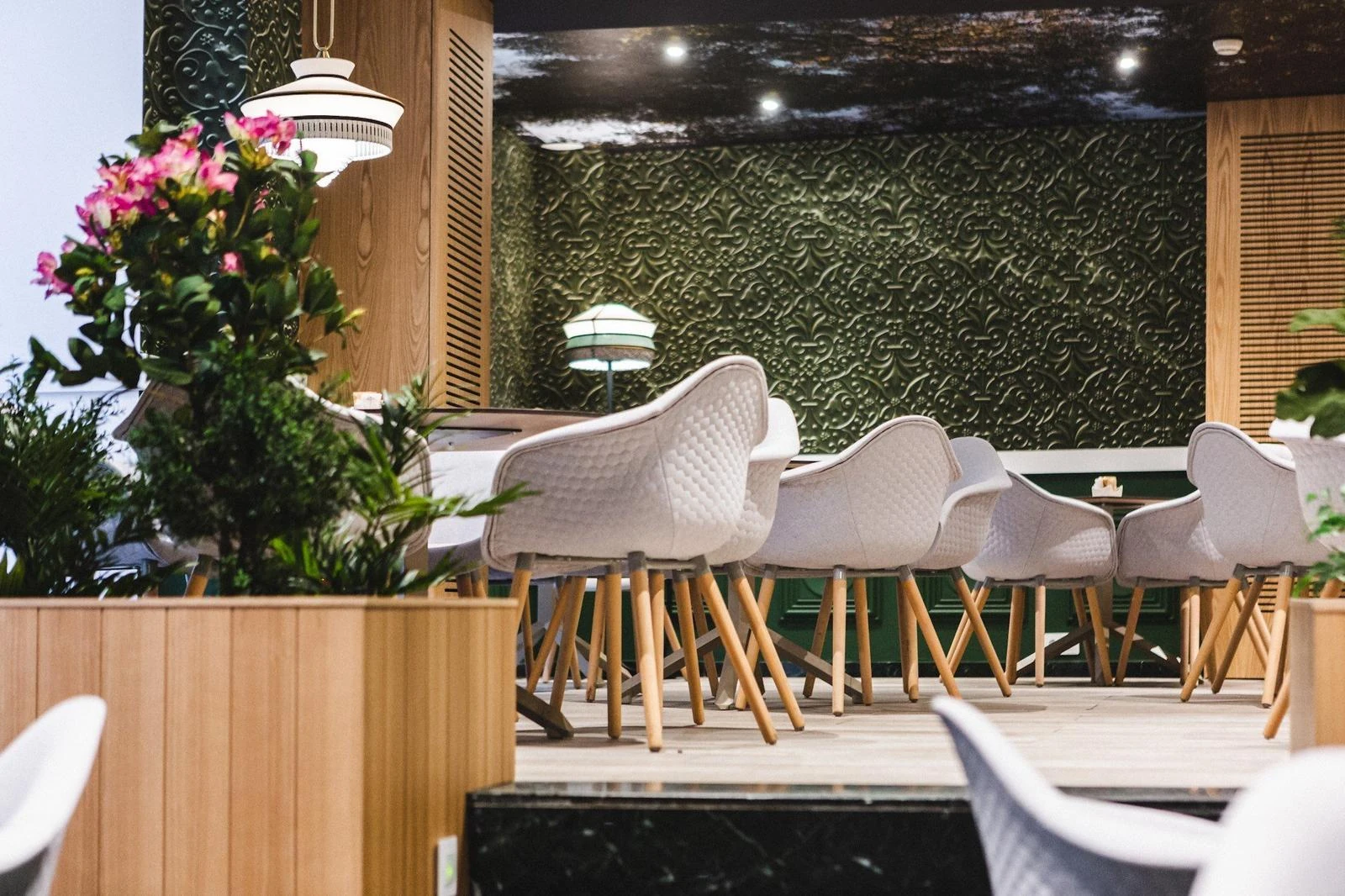 Mesas del restaurante Le Marquis, con asientos tapizados y pavimento de madera
