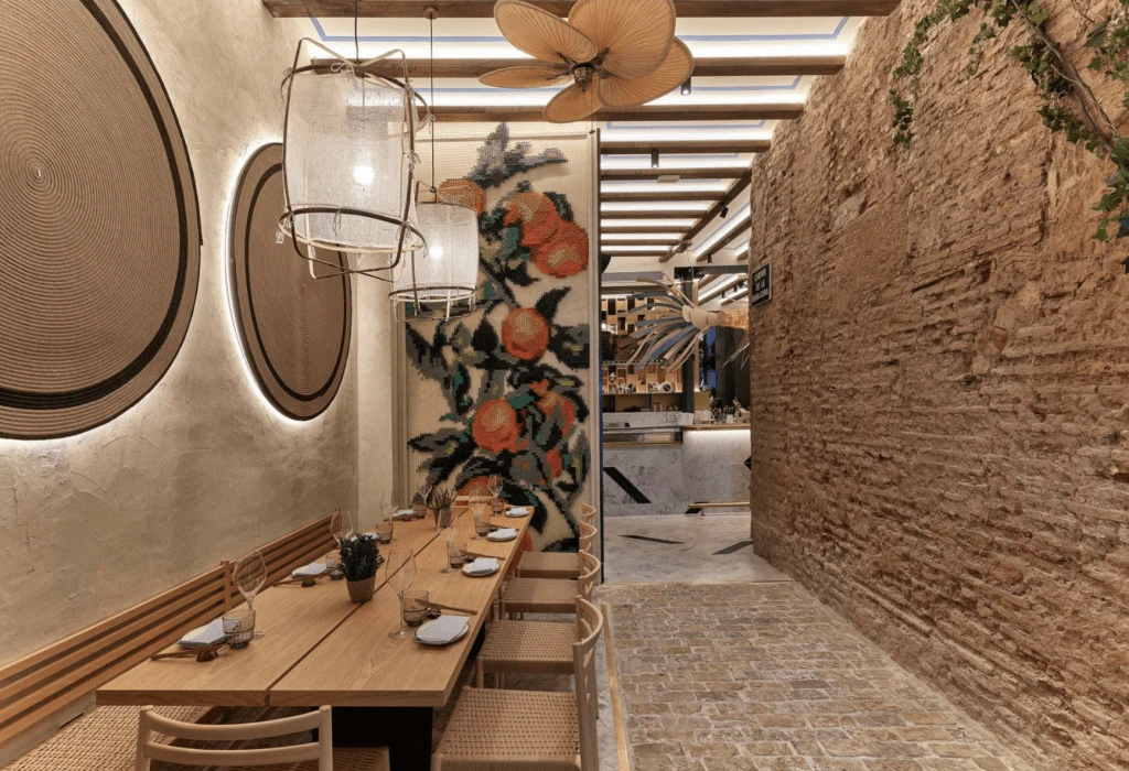 Mesa social de madera y sillas en uno de los ambientes interiores de Vaqueta